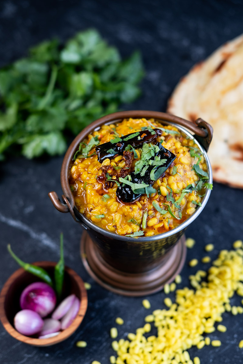 Daal Tadka Lentil and Beans with Herbs and red onion on a dark grey stone at Queen’s of India Kuta Bali